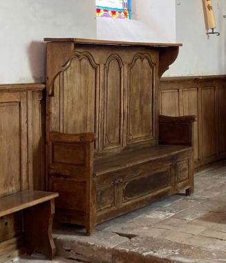Banc d’œuvre en bois restauré, placé dans le chœur